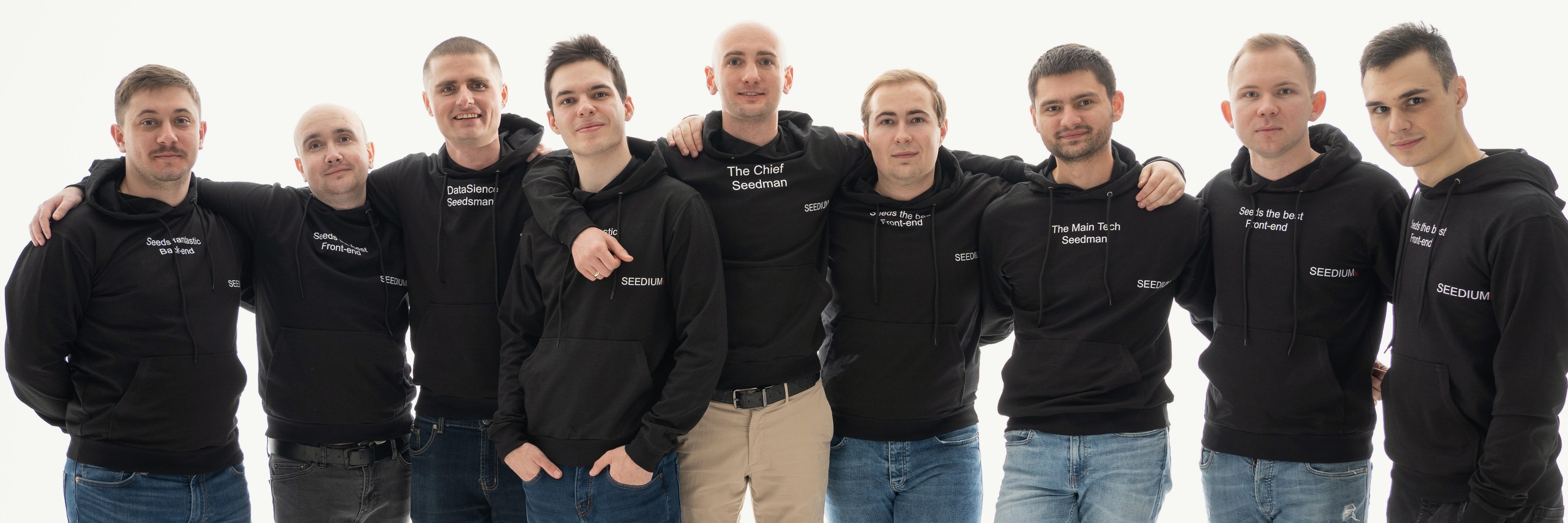 The Seedium engineering team, nine people standing arm in arm in Seedium hoodies